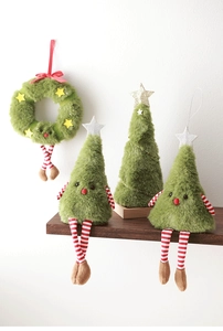 Dettaglio di alberi di Natale in peluche con gambe a strisce su scaffale di legno