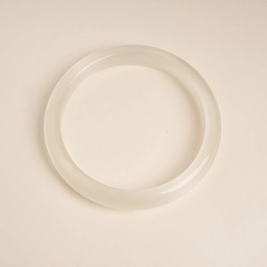 Detailed close-up of a smooth white cat-eye stone bangle with polished finish