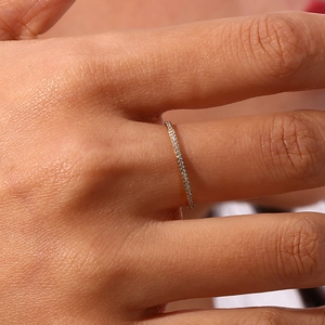 Macro shot of 18K gold plated thin ring with micro paved cubic zirconia on finger