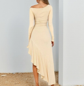Detail of light beige off-shoulder knit dress with asymmetrical wavy ruffled hemline