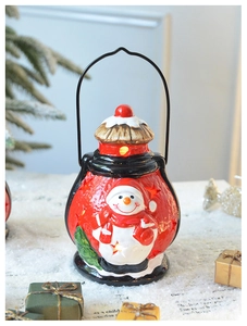 Détail de la lanterne bonhomme de neige en céramique rouge avec découpes d'étoiles