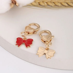 Detail of red and gold alloy bow pendants with heart-shaped clasps for DIY jewelry