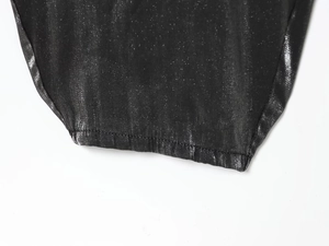 Détail du tissu à paillettes noires et des coutures fines sur la combinaison licou