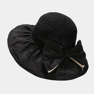 Close-up of black straw woven sun hat with foldable bow detail and UV protection fabric