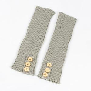 Detail of ribbed knit leg warmers in sage green featuring vintage wooden buttons