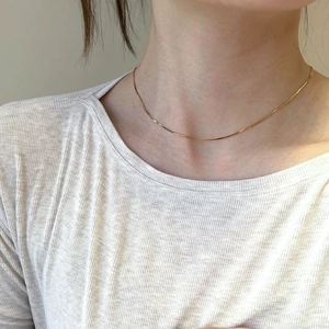 Minimalist 18K gold-plated snake bone chain necklace shown on a female model's neck