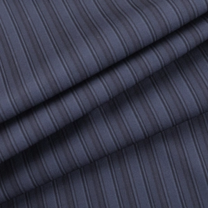 Détail macro du tissu à rayures bleu foncé montrant la texture et le drapé du pantalon