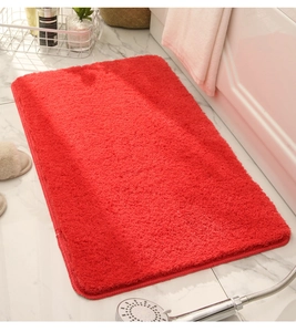 Close-up of red microfiber bathroom mat with soft plush texture and durable hemmed edges