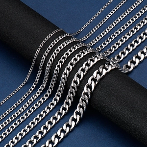 Macro detail of silver stainless steel Cuban link chains in various sizes on a black stand