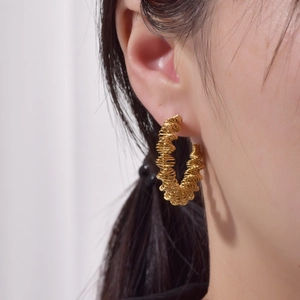 Detailansicht goldener 18K Creolen mit Schuppenmuster im eleganten Schlangen-Stil