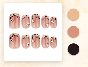 Detail of French leopard print press-on nails with golden floral rhinestone accents