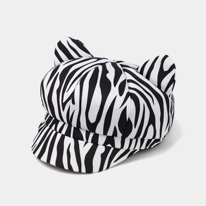 Detail view of zebra print newsboy cap featuring cute animal ears and canvas texture