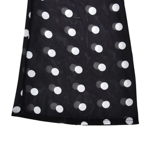 Detailed view of lightweight black chiffon fabric featuring a classic white polka dot pattern