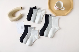 Flat lay of cotton socks in black, white, and grey with ribbed cuffs and soft texture