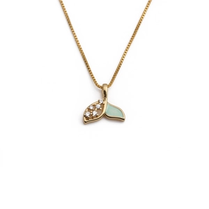 Macro view of gold fishtail necklace with sparkling zircon and green enamel detail