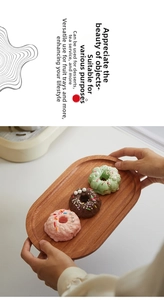 Ovaal dienblad van zwart walnotenhout voor het serveren van donuts in huiselijke sfeer