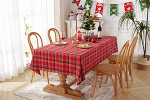 Detailed close-up of red and green plaid Christmas tablecloth with decorative tassels