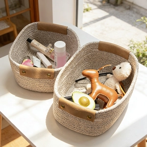 Detail of cream cotton rope storage basket with brown leather handles and metal rivets