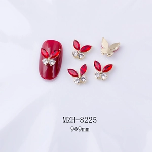 Gros plan de bijoux d'ongles papillon en strass rouge 3D sur fond de satin blanc