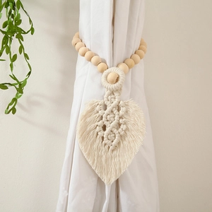 Detail of hand-woven cotton leaf curtain tieback with natural wooden beads decoration