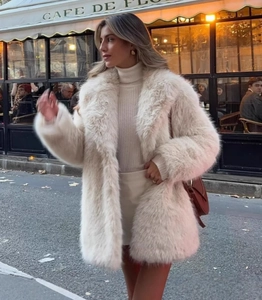 Vue extérieure d'un manteau en fausse fourrure crème avec col roulé blanc et sac marron