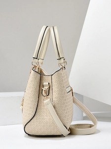 Close-up of beige woven texture handbag with golden hardware and adjustable strap