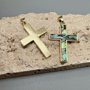 Golden cross pendants with mesh texture and rainbow abalone shell inlay on stone