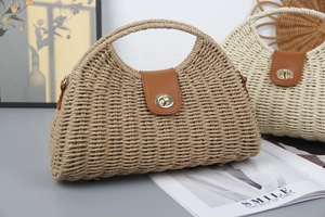 Detail of straw woven crescent bags in brown and beige with leather locks