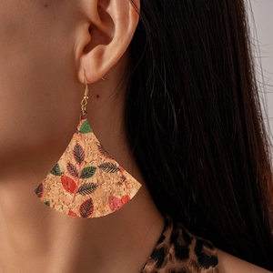 Gros plan de boucles d'oreilles en liège en éventail avec motifs de feuilles