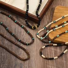 Detail view of gothic men's beaded necklaces with wooden and coconut shell beads on wood