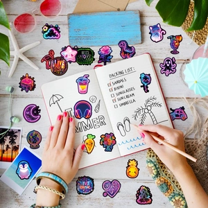 Neon style waterproof stickers with summer and animal themes on a white wooden desk