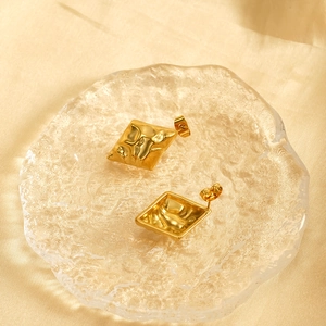 18k gold plated stainless steel rhombus earrings with hammered texture on silk background
