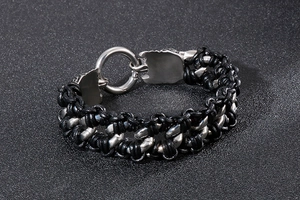 Close-up of braided leather and steel chain link detail on punk style dragon bracelet