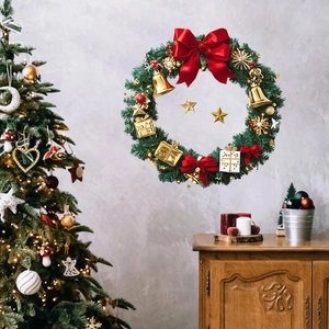 Christmas wreath with red silk bow, gold bells, and stars on green pine needles decoration