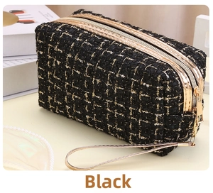 Nahaufnahme der schwarzen Tweed-Kosmetiktasche mit goldenem Reißverschluss und Textur
