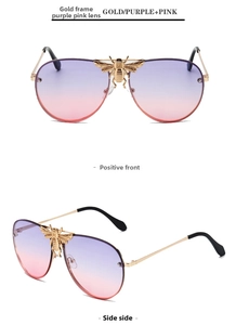 Detail of bee emblem and purple gradient lenses on gold metal aviator sunglasses