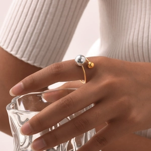 Minimalist stainless steel open ring with gold and silver beads on model's hand