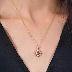 Detailansicht der Goldkette mit Zirkonia-Blumenanhänger und rotem Edelsteinzentrum