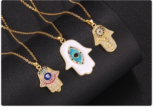 Close-up of gold-plated Hamsa Hand pendants with Evil Eye and colorful rhinestones