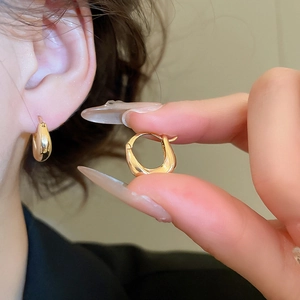 Close-up of minimalist 18K gold plated U-shaped earrings on model for elegant style