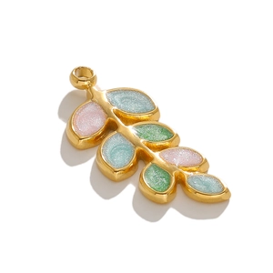 Detailed macro view of gold leaf charms with pink, blue, and green glitter enamel inlays