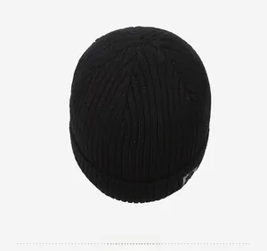 Top view of a black ribbed knit beanie showing multi-seam closure and side patch detail