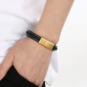 Gros plan d'un bracelet tressé en cuir noir pour homme avec fermoir magnétique doré