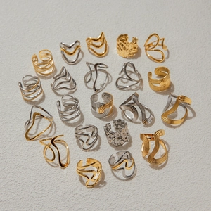 Close-up of golden and silver irregular wave rings with artistic lava texture