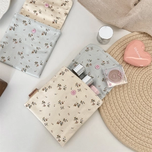 Detailed view of floral cotton storage pouches with pink snap buttons and brand label