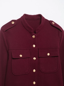 Détail d'une veste en laine bordeaux avec col montant et boutons dorés en métal