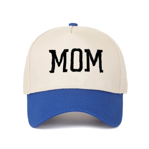 Close-up of beige and royal blue trucker hat with black MOM embroidery detailing