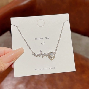 Detail showing heartbeat lightning pendant with heart-shaped zircon on silver chain