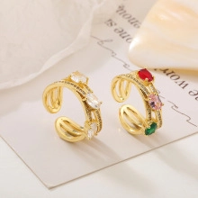 Detailed macro view of adjustable golden rings with white and colorful zircon settings