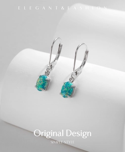 Detail of silver drop earrings featuring oval blue opal stones and secure lever backs